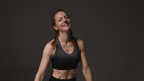 Studio-Portrait-Of-Mature-Woman-Wearing-Gym-Fitness-Clothing-Resting-And-Recovering-After-Exercise